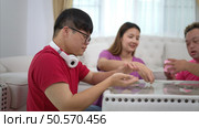 Three siblings save money by putting it in a piggy bank, This is an activity that parents teach their children about saving money. Стоковое фото, агентство Ingram Publishing / Фотобанк Лори