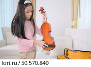 A girl violinist sets up and tunes a violin. Стоковое фото, агентство Ingram Publishing / Фотобанк Лори
