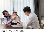 Father and mother feed their son breakfast before going to work in the kitchen of the house. Стоковое фото, агентство Ingram Publishing / Фотобанк Лори