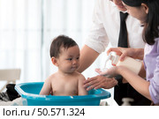 Father and mother bathe their son after they come home from work. Стоковое фото, агентство Ingram Publishing / Фотобанк Лори