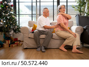 Grandfather and grandmother are giving each other a relaxing massage while waiting to meet their children and grandchildren, who will join them for a meal during the Christmas holiday at home. Стоковое фото, агентство Ingram Publishing / Фотобанк Лори