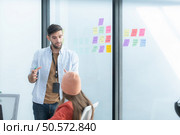 Multiethnic startup business team on meeting in modern bright office interior brainstorming, working on laptop and tablet computer. Стоковое фото, агентство Ingram Publishing / Фотобанк Лори