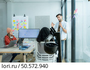 Multiethnic startup business team on meeting in modern bright office interior brainstorming, working on laptop and tablet computer. Стоковое фото, агентство Ingram Publishing / Фотобанк Лори