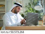 Portrait of young Arabic businessman working on laptop at home. Стоковое фото, агентство Ingram Publishing / Фотобанк Лори