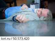 An elderly businessman fell to the floor with sudden heart failure at work. Стоковое фото, агентство Ingram Publishing / Фотобанк Лори