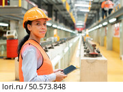 Portrait of a young female engineer standing in the skytrain repair station. Стоковое фото, агентство Ingram Publishing / Фотобанк Лори