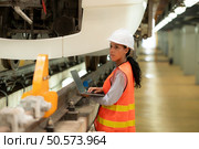 Female engineers work together in an electric repair station. Inspect head of electric trains that come in for repairs in the skytrain repair station. Стоковое фото, агентство Ingram Publishing / Фотобанк Лори