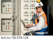 Before proceeding with the testing, Electrical engineer inspects the installed control panel. Стоковое фото, агентство Ingram Publishing / Фотобанк Лори