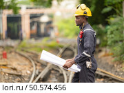 Railway technicians, Working on the train tracks at train station. Стоковое фото, агентство Ingram Publishing / Фотобанк Лори