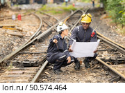 Railway technicians and engineers, Working on the train tracks at train station. Стоковое фото, агентство Ingram Publishing / Фотобанк Лори