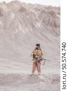 A Taliban soldier stands with a machine gun, In the desert mountain landscape. Стоковое фото, агентство Ingram Publishing / Фотобанк Лори