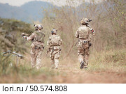 Soldiers in camouflage military uniforms carrying weapons, Reconnaissance missions in the tropical forest area, Assault infantry battle training. Стоковое фото, агентство Ingram Publishing / Фотобанк Лори