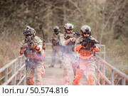 Soldiers in camouflage military uniforms carrying weapons, Reconnaissance missions in the tropical forest area, Assault infantry battle training. Стоковое фото, агентство Ingram Publishing / Фотобанк Лори