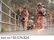 Soldiers in camouflage military uniforms carrying weapons, Reconnaissance missions in the tropical forest area, Assault infantry battle training. Стоковое фото, агентство Ingram Publishing / Фотобанк Лори