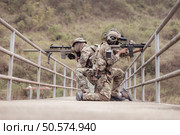 Soldiers in camouflage military uniforms carrying weapons, Reconnaissance missions in the tropical forest area, Assault infantry battle training. Стоковое фото, агентство Ingram Publishing / Фотобанк Лори