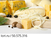 Various types of cheese with spice on the wooden board. Стоковое фото, агентство Ingram Publishing / Фотобанк Лори