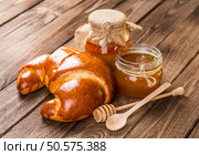 Tasty croissants with spikelets on grey wooden background. Стоковое фото, агентство Ingram Publishing / Фотобанк Лори