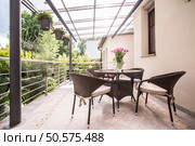 Photo of neat rattan chairs and table standing on terrace. Стоковое фото, агентство Ingram Publishing / Фотобанк Лори