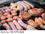 Raw Meat skewer on barbecue grill with coal. Cevapcici, sausages, chicken wings, pork ribs and steak on charcoal barbecue BBQ. Стоковое фото, агентство Ingram Publishing / Фотобанк Лори
