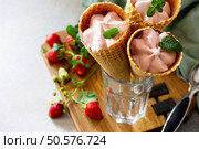 Strawberry of ice cream scoops in cones on a light stone or slate table. Free space for your text. Стоковое фото, агентство Ingram Publishing / Фотобанк Лори