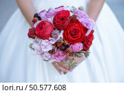 Beautiful bride is holding a wedding colorful bouquet. Beauty of colored flowers. Close-up bunch of florets. Bridal accessories. Female decoration for girl. Details for marriage and for married couple. Beautiful bride is holding a wedding colorful bouquet. Стоковое фото, агентство Ingram Publishing / Фотобанк Лори