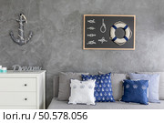 Modern flat with nautical decorations, sofa with pattern pillows and white commode. Стоковое фото, агентство Ingram Publishing / Фотобанк Лори