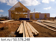 New home under construction with wood, trusses and supplies. Стоковое фото, агентство Ingram Publishing / Фотобанк Лори