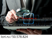 Businessman looks for the malicious code of a virus. Стоковое фото, агентство Ingram Publishing / Фотобанк Лори