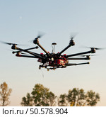 Drone on a background of a beautiful sunset. UAV in flight. Quadrocopters on radio.. Oktokopter, copter, drone. Стоковое фото, агентство Ingram Publishing / Фотобанк Лори