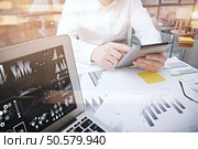 Investment manager working process.Photo trader work market report modern tablet.Using electronic devices.Graphic icons,stock exchange reports screen laptop.Business project startup. Horizontal. Investment manager working process.Photo trader work market report modern tablet.Using electronic devices.Graphic icons,stock exchanges reports screen laptop.Business project startup.Film effect. Стоковое фото, агентство Ingram Publishing / Фотобанк Лори