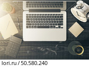 Top view of desktop with blank notepad, laptop, coffee, flowers and other items. Mock up. Стоковое фото, агентство Ingram Publishing / Фотобанк Лори