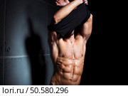 Muscular and sexy torso of young sport man. Attractive bodybuilder body with perfect abs, chest, bicep, triceps. Muscular and sexy torso of young sport man. Bodybuilder body with perfect abs, chest, bicep, triceps. Hunk taking off his shirt. Стоковое фото, агентство Ingram Publishing / Фотобанк Лори
