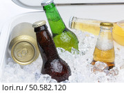 Close up of an assortment of beer bottles and cans in cooler with ice horizontal composition. Стоковое фото, агентство Ingram Publishing / Фотобанк Лори