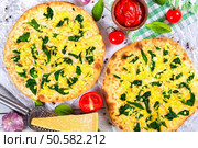 Vegetarian pizza with spinach leaves, parmesan cheese. tomatoes and homemade salsa in bowl, pepper, garlic and grater with piece of parmesan cheese on wooden boards, close-up, top view. Стоковое фото, агентство Ingram Publishing / Фотобанк Лори