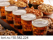 Beer and snacks on wooden background football fan set. Стоковое фото, агентство Ingram Publishing / Фотобанк Лори