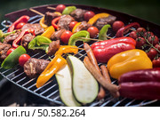 Delicious skewers and vegetables barbecued on a grill. Skewers on a grill. Стоковое фото, агентство Ingram Publishing / Фотобанк Лори