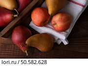 Fresh picked pears and apples in a wood crate and towel on a rustic wood table. Top view in horizontal format. . Стоковое фото, агентство Ingram Publishing / Фотобанк Лори
