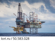 Oil and gas drilling rig work over remote wellhead platform to completion oil and gas produce well by using drilling bit which made from carbide or diamond at head bit and drive by mud pressure. Стоковое фото, агентство Ingram Publishing / Фотобанк Лори