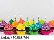 Rows of colorful cup cakes decorated with birthday candles and sprinkles.. Birthday Cupcakes. Стоковое фото, агентство Ingram Publishing / Фотобанк Лори