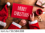 Santa Claus holding an empty wish list in his hands. Santa Claus and wishlist. Стоковое фото, агентство Ingram Publishing / Фотобанк Лори