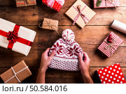 Christmas presents laid on a wooden table background. Christmas presents on a table. Стоковое фото, агентство Ingram Publishing / Фотобанк Лори