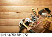 tools in tool belt on wood planks with copy space. Стоковое фото, агентство Ingram Publishing / Фотобанк Лори
