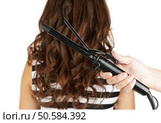 Stylist using curling iron for hair curls, close-up, isolated on white. Стоковое фото, агентство Ingram Publishing / Фотобанк Лори
