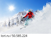 Freeride skier with rucksack running downhill in freeze motion of snow powder.. Freeride skier on piste running downhill. Стоковое фото, агентство Ingram Publishing / Фотобанк Лори