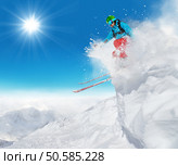 Freeride skier jumping from rock in freeze motion of snow powder.. Freeride skier jumping from rock. Стоковое фото, агентство Ingram Publishing / Фотобанк Лори