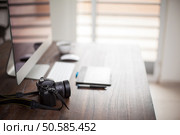 Profile view of the desk or a photographer with a digital camera, a pen tablet and lots of bokeh. Photographer’s workspace with bokeh. Стоковое фото, агентство Ingram Publishing / Фотобанк Лори