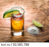 Single shot of tequila served with lime and salt on the wooden background. Стоковое фото, агентство Ingram Publishing / Фотобанк Лори