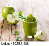Glass of apple puree with a fresh apple decorated with leaves of mint on a rustic wooden background with copy space. Стоковое фото, агентство Ingram Publishing / Фотобанк Лори