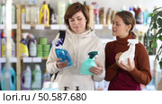 Girl consultant helps woman buyer choose household chemical spray. Стоковое видео, видеограф Яков Филимонов / Фотобанк Лори