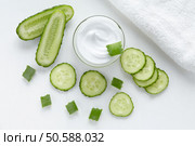 Cucumber and aloe cosmetic cream face, skin and body care hygiene moisture lotion wellness therapy mask in glass jar with towel on white background. Cucumber and aloe cosmetic cream face, skin, body care. Стоковое фото, агентство Ingram Publishing / Фотобанк Лори
